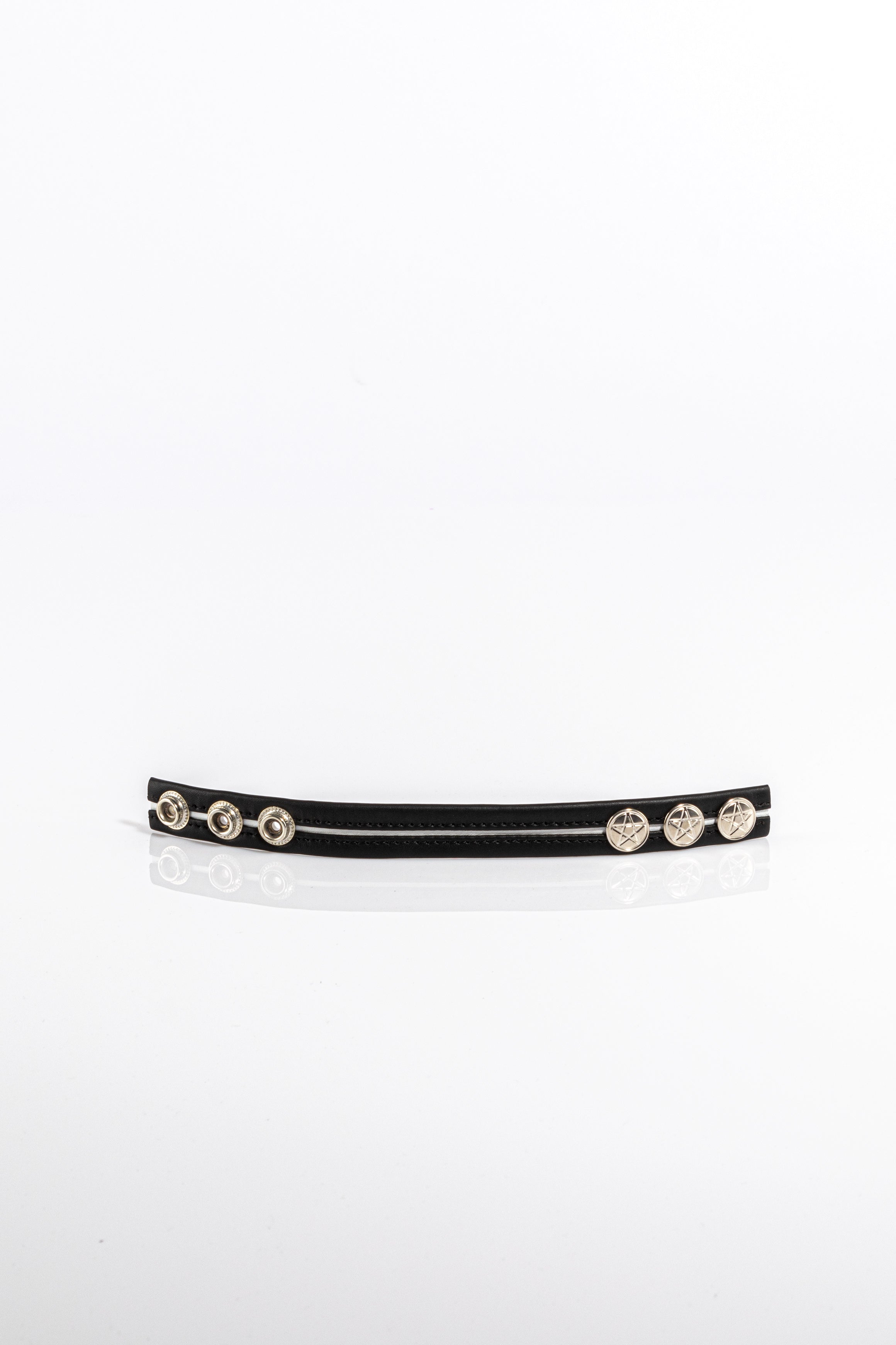 A product photo of a black cock ring with white trim.