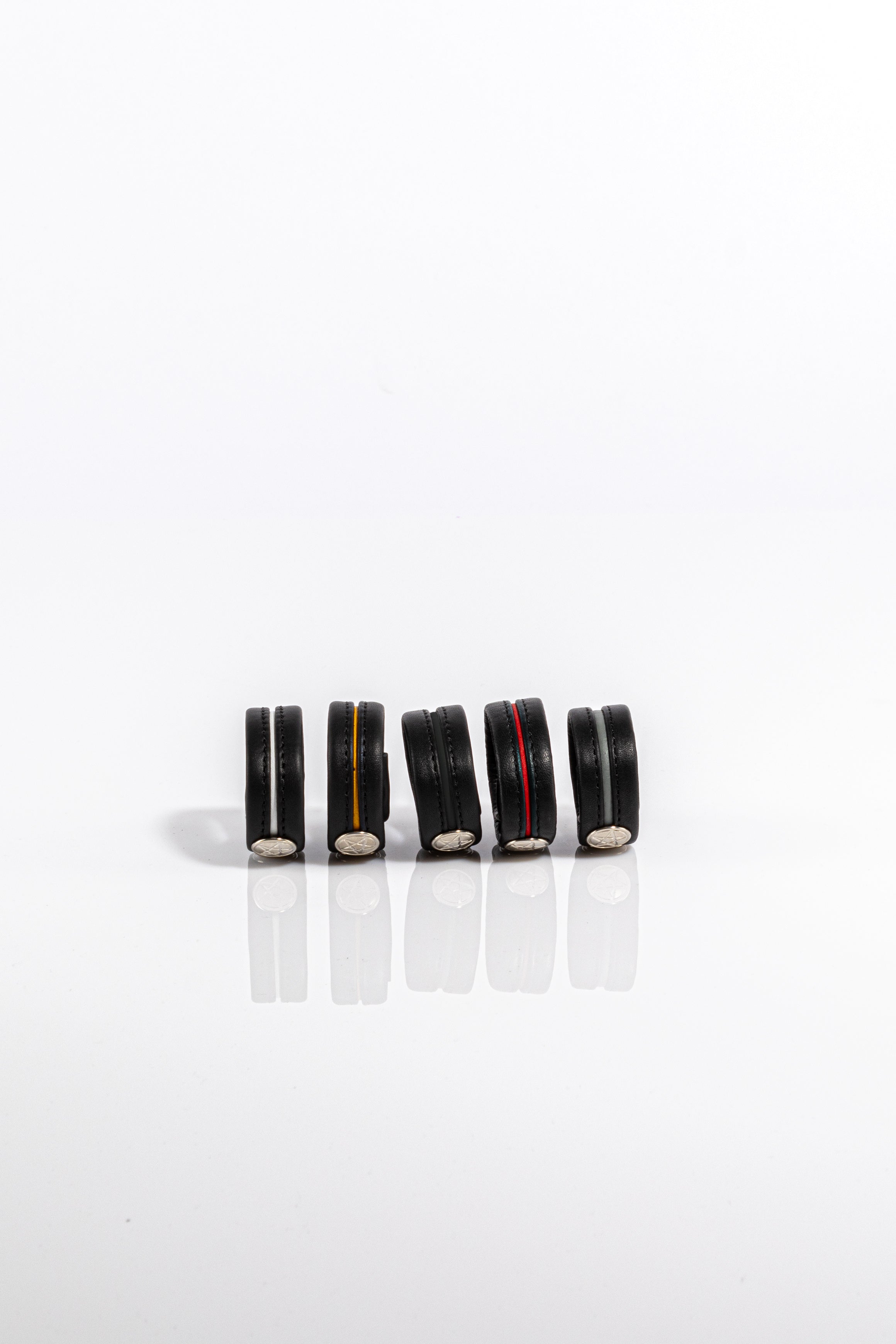 A product photo of five different coloured cock rings.