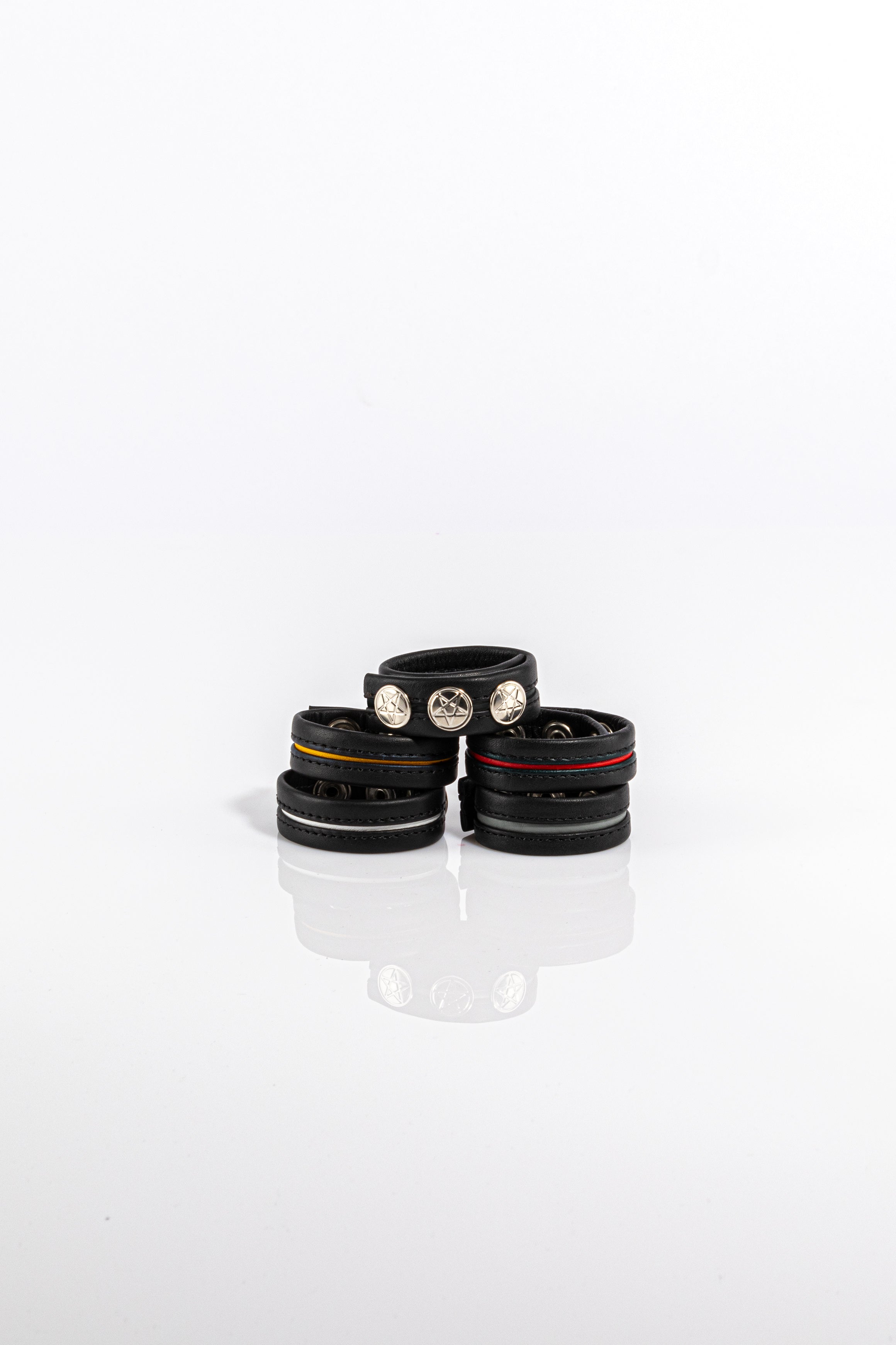 A product photo of five black and coloured cock rings. 