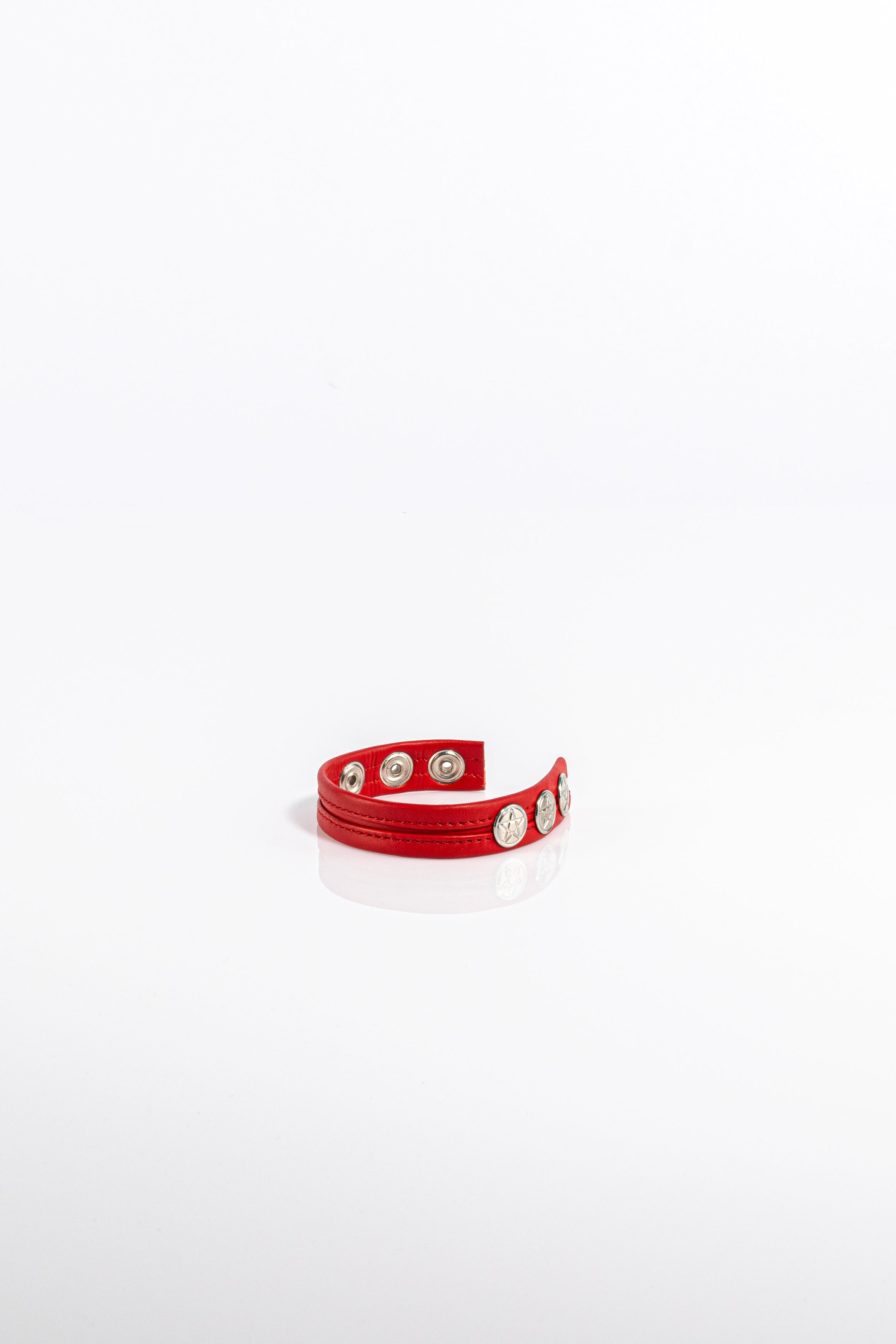 A product photo of a solid red cock ring.