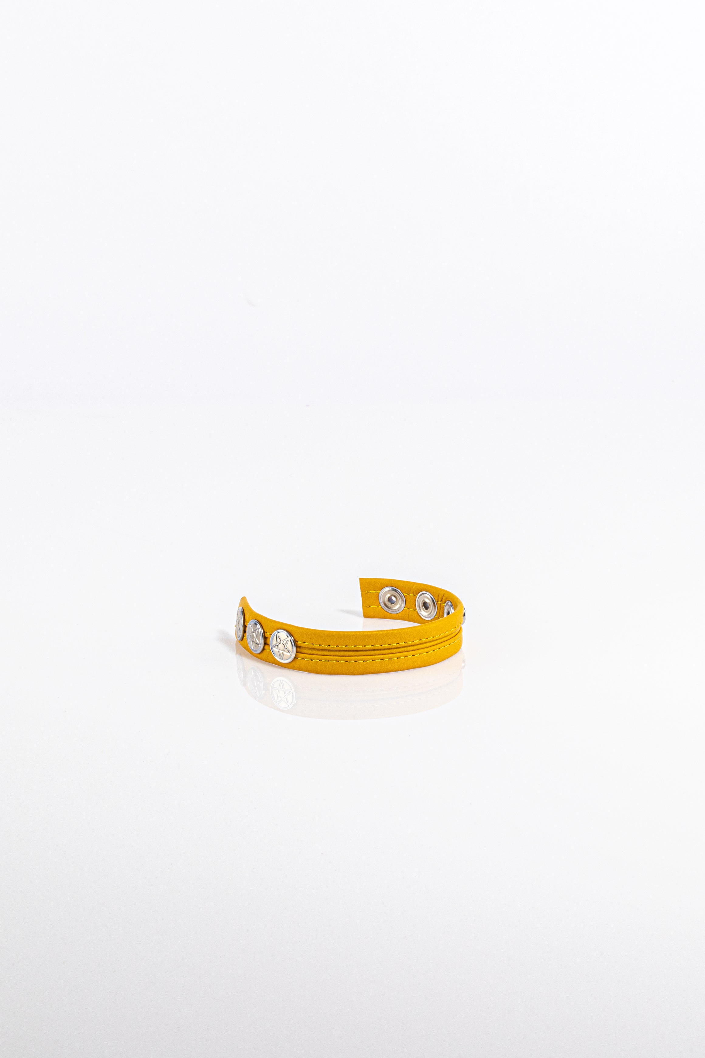 A product photo of a solid yellow leather cock ring.
